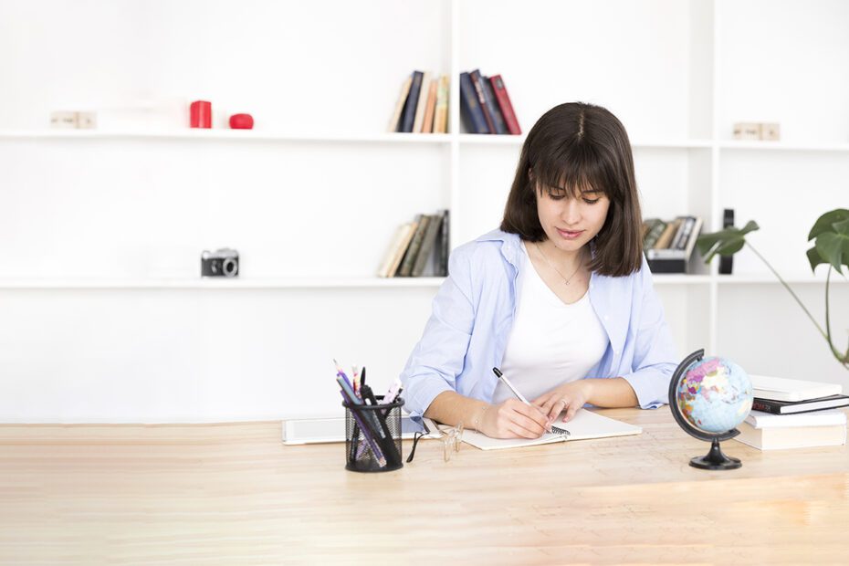 Studentin am Schreibtisch beim Schreiben
