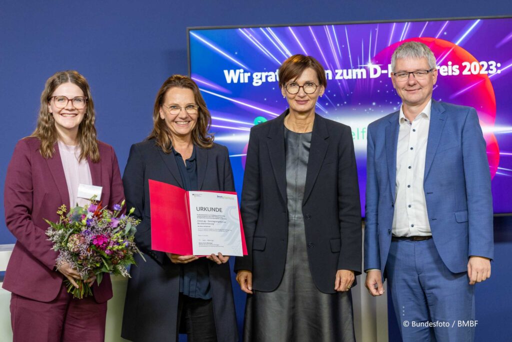 Lhea Rheinhold und Stephanie Pohlmann von future.self nehmen die D-BOP Auszeichnung von Bundesbildungsministerin Bettina Stark-Watzinger entgegen