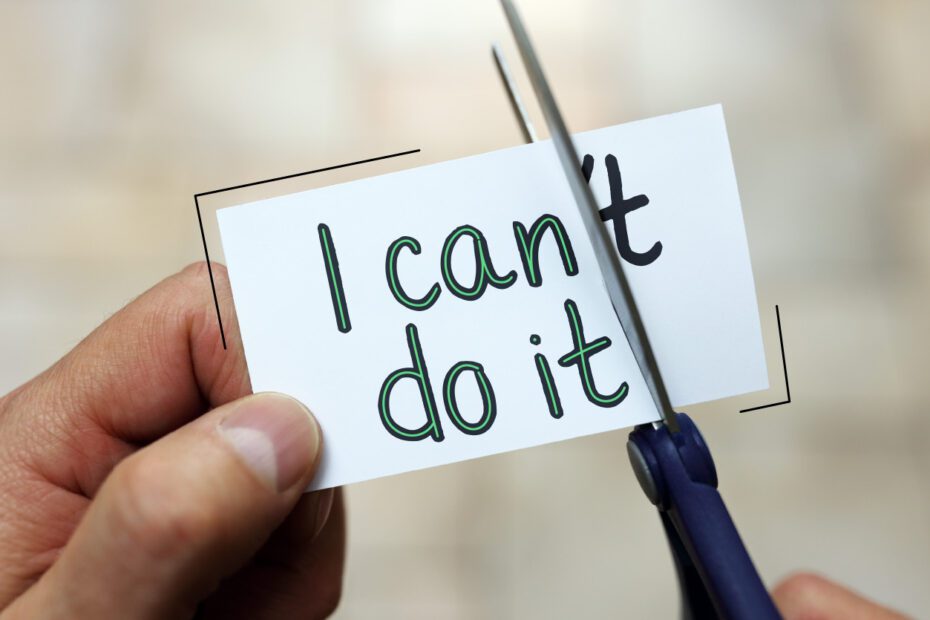 Aus "I can't do it" auf einem Zettel wird "I can do it" gemacht, indem mit der Schere die Verneinung abgeschnitten wird.