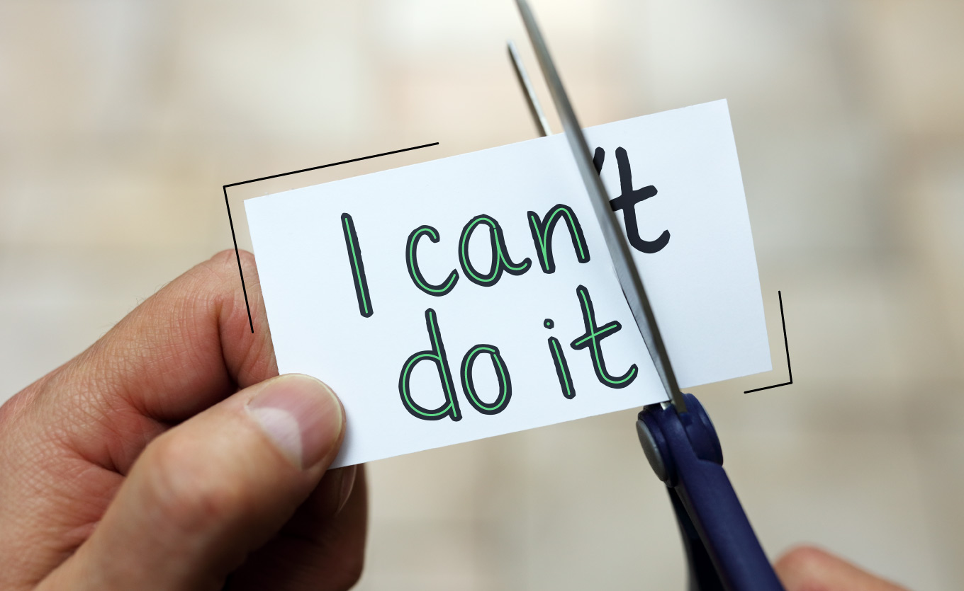 Aus "I can't do it" auf einem Zettel wird "I can do it" gemacht, indem mit der Schere die Verneinung abgeschnitten wird.